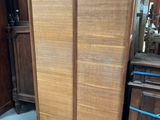 une armoire en bois dans une pièce où se trouve un miroir accroché au mur