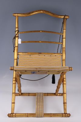 une chaise dorée avec une assise en bois sur fond gris