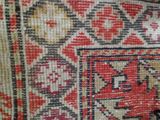 a close up of a rug with a red and black design