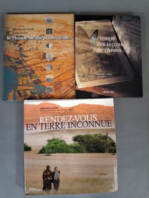 trois livres posés sur une table, dont l'un est une carte et l'autre une photo d'un homme à cheval