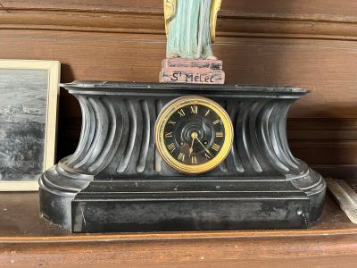 une statue de Jésus posée au sommet d'une horloge, sur une étagère