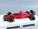 une maquette de voiture de course rouge posée sur un socle blanc