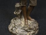 bronze statue of a boy with a dog on a rock