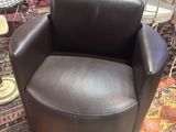 brown leather swive chair on a rug in a store