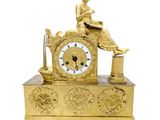 une horloge en or avec une femme assise dessus