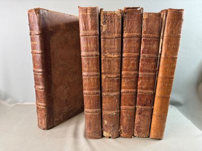 three old books are stacked on top of each other on a table