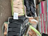 de nombreuses paires de chaussures dans des cartons posés par terre