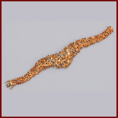 un bracelet en or orné de nombreux petits éléments en or