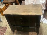 une commode noire surmontée de trois tiroirs