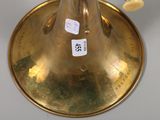 a gold vase with a flower in it sitting on a table