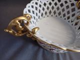 a white bowl with a gold handle on a table
