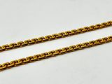 a close up of two gold chains on a white surface