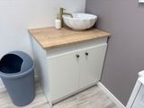 a sink and a trash can in a small bathroom