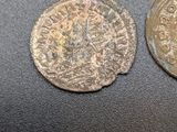 two coins sitting on top of a black surface next to each other