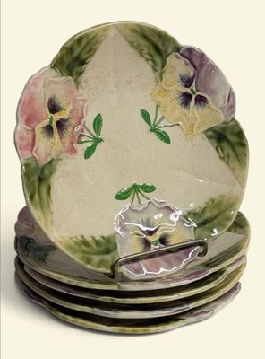 quatre assiettes empilées les unes sur les autres, ornées de pensées peintes