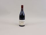 une bouteille de vin rouge posée sur une table blanche