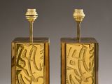pair of brass candlesticks with etched designs on the sides