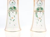 two vases with flowers painted on them on a white surface