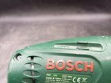 a green and red cordless drill on a table