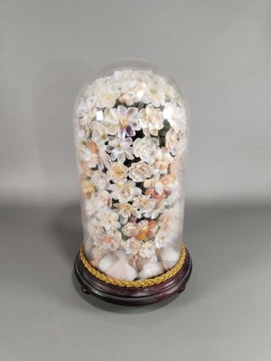 une cloche en verre contenant des coquillages, posée sur une table