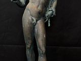 bronze statue of a man holding a knife on a pedestal
