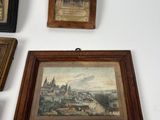 three framed pictures of a city and a town on a wall