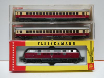 three model trains sitting in a box on a white surface