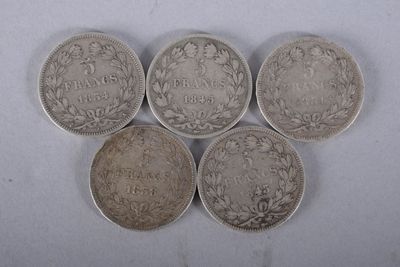 quatre pièces d'argent sont disposées en ligne sur une surface blanche