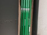 a cardboard box with a bunch of green pencils in it