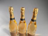 three bottles of champagne sitting on top of a table next to each other