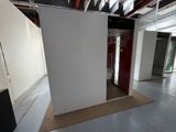 une pièce avec une cloison blanche et une porte rouge
