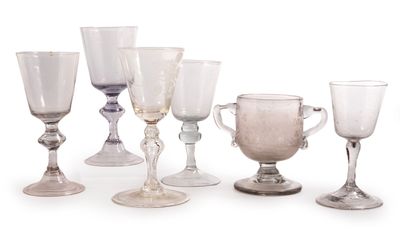 six verres à vin posés les uns à côté des autres sur une surface blanche
