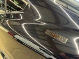 a close up of a shiny black car with a sticker on it