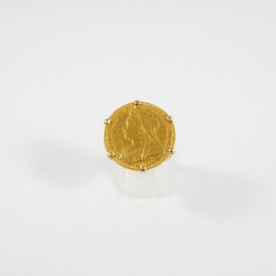 gros plan d'une pièce d'or sur une surface blanche