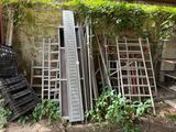 un tas d'échelles et un tas de chaises dans la cour