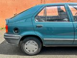 a small blue car parked in a parking lot