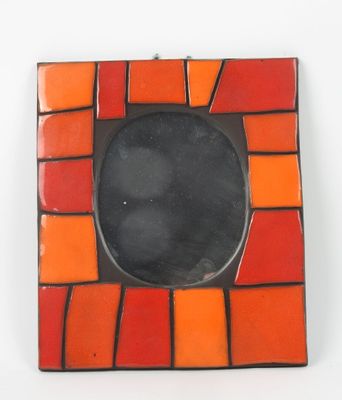 un cadre photo orange et noir posé sur une table blanche