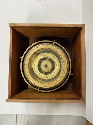 une boîte en bois contenant une horloge, accrochée au mur