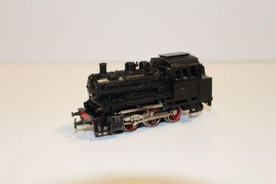 un petit train sur une surface blanche avec un fond blanc