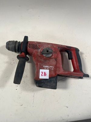 une perceuse rouge posée sur une table