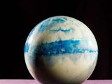 a blue and white marble ball sitting on a table