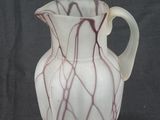 a white and red vase on a black background