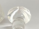 two clear glass vases sitting on top of a white surface