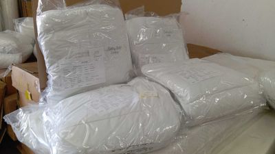 plusieurs sacs remplis d'oreillers posés sur un lit dans une chambre