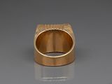 a close up of a gold ring on a white surface