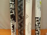 four baseball bats are lined up on a table next to a cup of coffee