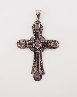 a silver cross with purple stones on a white background