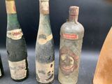 several old bottles of alcohol are lined up on a table