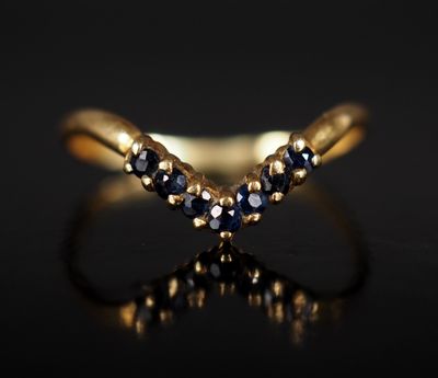 gros plan d'une bague en or avec des saphirs bleus