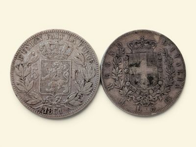 une vieille pièce de monnaie sur laquelle figurent des armoiries et une couronne
